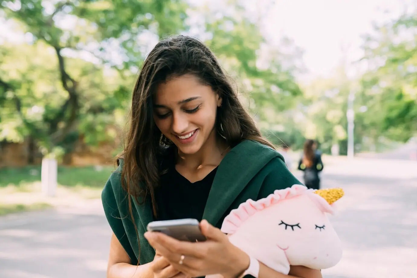 A young, attractive woman typing messages on her mobile.